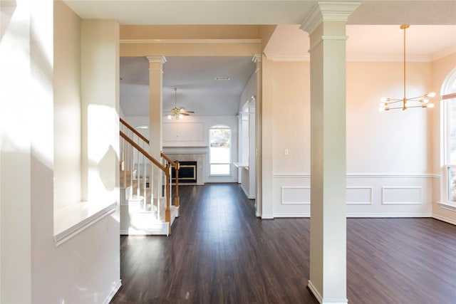 7104 Hillview Dr, Plano, TX 75025 - foyer with dark wood finished floors, ceiling fan with notable chandelier, a wainscoted wall, stairs, and decorative columns
