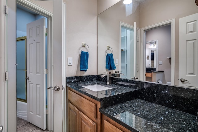 12215 Lake Forest Dr, Azle, TX 76020 - bathroom featuring vanity, tile patterned floors, enclosed tub / shower combo, and toilet