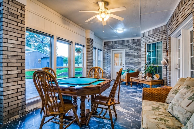 12215 Lake Forest Dr, Azle, TX 76020 - dining area featuring marble look tile flooring, a ceiling fan, and brick wall