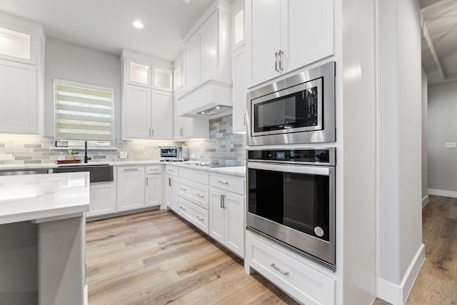4120 Sandhills Ln, Prosper, TX 75078 - kitchen with stainless steel appliances, light wood finished floors, tasteful backsplash, white cabinets, and recessed lighting