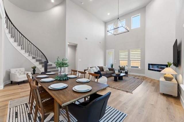 4120 Sandhills Ln, Prosper, TX 75078 - dining room featuring stairs, light wood finished floors, a high ceiling, baseboards, and a chandelier