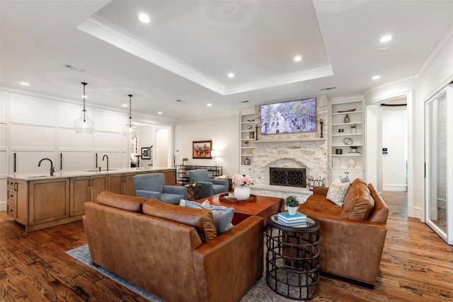 6405 Carmel Falls Ct, Mckinney, TX 75072 - living area with crown molding, dark wood finished floors, and a stone fireplace