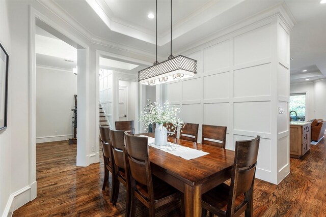 6405 Carmel Falls Ct, Mckinney, TX 75072 - dining space featuring crown molding, a raised ceiling, a decorative wall, recessed lighting, and dark wood-style floors