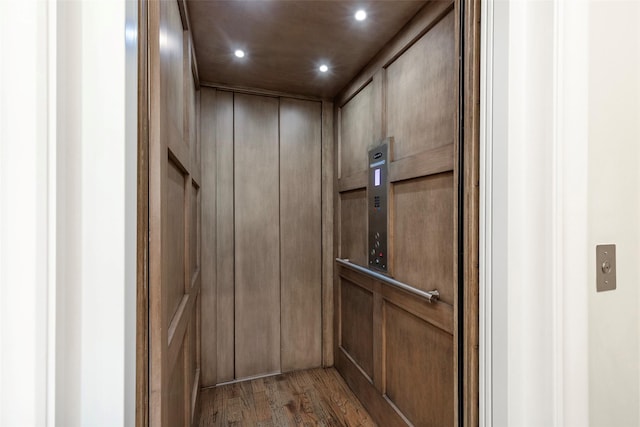 6405 Carmel Falls Ct, Mckinney, TX 75072 - room details featuring recessed lighting, wood walls, wood finished floors, and elevator