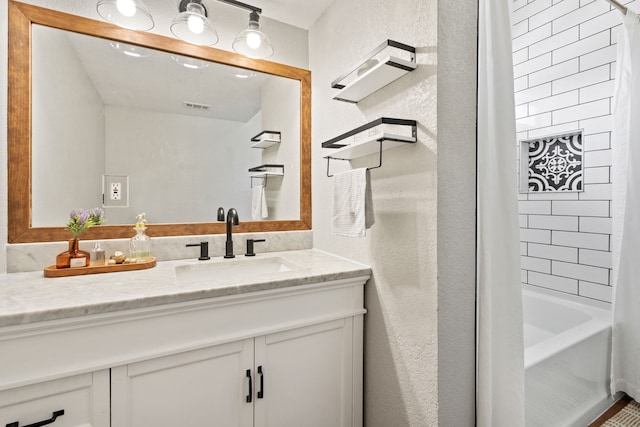 3901 Travis St Unit 121, Dallas, TX 75204 - full bathroom with vanity, a textured wall, and shower / bath combo