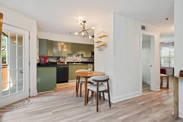 3901 Travis St Unit 121, Dallas, TX 75204 - kitchen featuring dishwasher, green cabinets, a chandelier, dark countertops, and light wood-style flooring