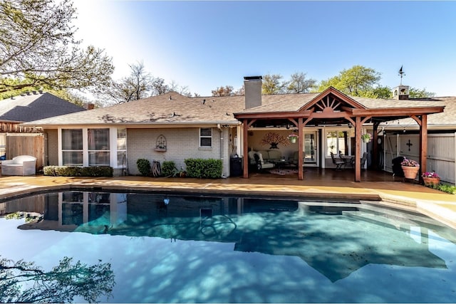 1470 Meandering Way, Rockwall, TX 75087 - rear view of house with fence, a patio, a chimney, and an outdoor pool