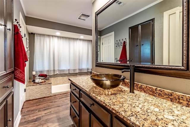1470 Meandering Way, Rockwall, TX 75087 - full bathroom with vanity, wood finished floors, visible vents, ornamental molding, and a bath