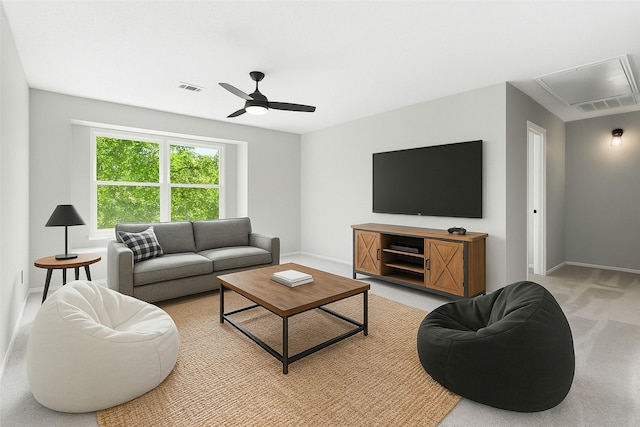 living area with visible vents, baseboards, attic access, and ceiling fan