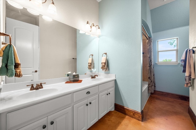 full bath with a textured wall, a sink, double vanity, and finished concrete flooring