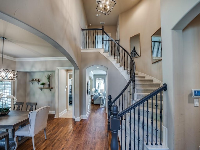 7212 Millard Pond Dr, Mckinney, TX 75071 - foyer entrance with arched walkways, an inviting chandelier, ornamental molding, wood finished floors, and stairs