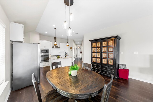 7600 W Fork Ln, Mckinney, TX 75071 - kitchen featuring stainless steel appliances, wall chimney exhaust hood, dark wood-style floors, a kitchen island with sink, and recessed lighting