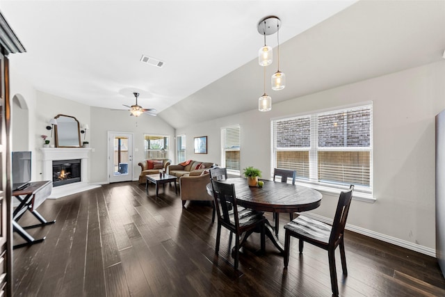 7600 W Fork Ln, Mckinney, TX 75071 - dining space with a glass covered fireplace, baseboards, dark wood-style floors, a ceiling fan, and vaulted ceiling