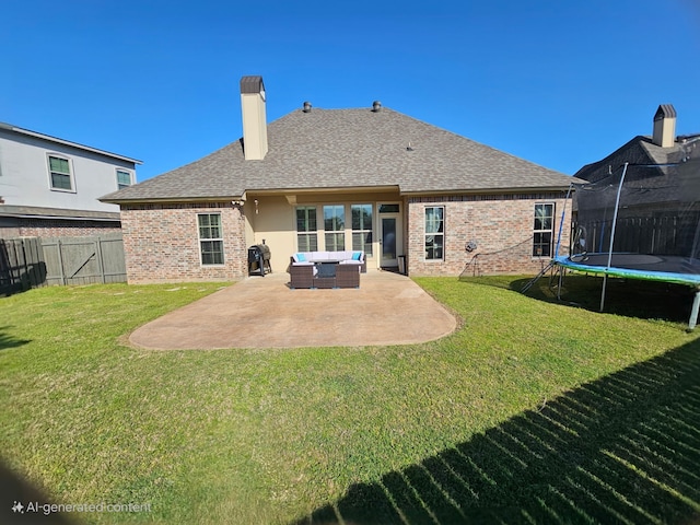 back of house with a yard, brick siding, a trampoline, and a patio area