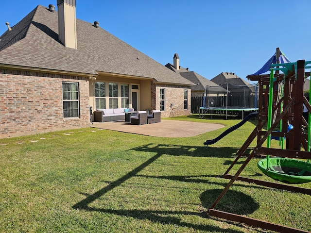 back of house with a playground, brick siding, an outdoor living space, and a trampoline