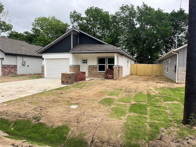 view of front of property featuring fence, roof with shingles, brick siding, concrete driveway, and an attached garage