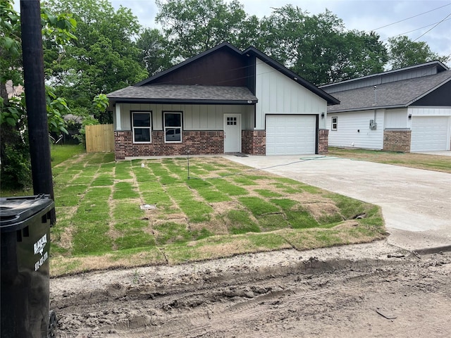view of front of house featuring brick siding, fence, concrete driveway, an attached garage, and a shingled roof