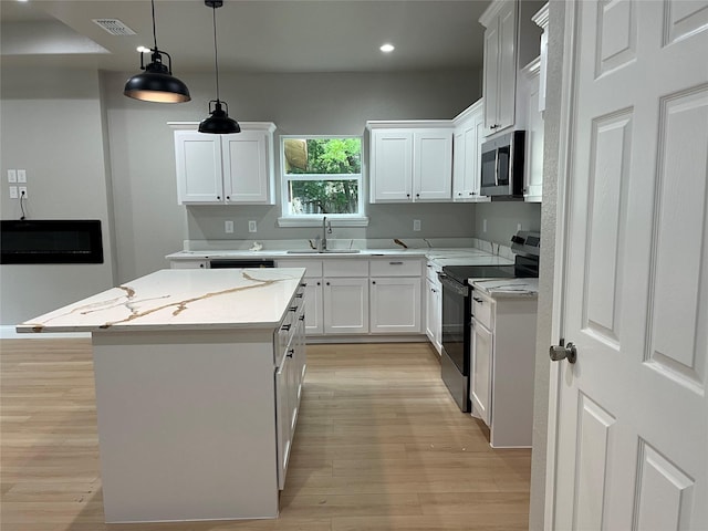 kitchen featuring a sink, light wood-style floors, black electric range, recessed lighting, and stainless steel microwave