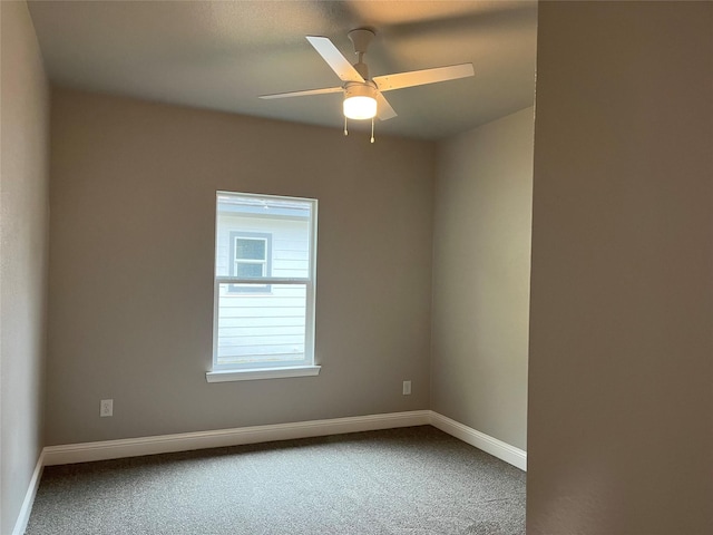 carpeted empty room with baseboards and a ceiling fan