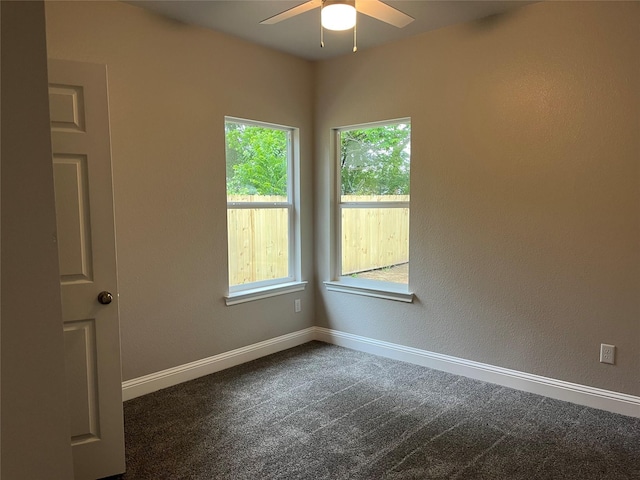 empty room with baseboards, ceiling fan, and dark carpet