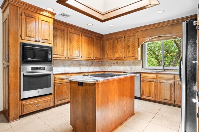 10019 Lost Oak Ridge Dr, Woodway, TX 76712 - kitchen with stainless steel appliances, a kitchen island, tasteful backsplash, light countertops, and light tile patterned floors