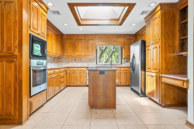 10019 Lost Oak Ridge Dr, Woodway, TX 76712 - kitchen with black appliances, recessed lighting, a center island, decorative backsplash, and brown cabinets