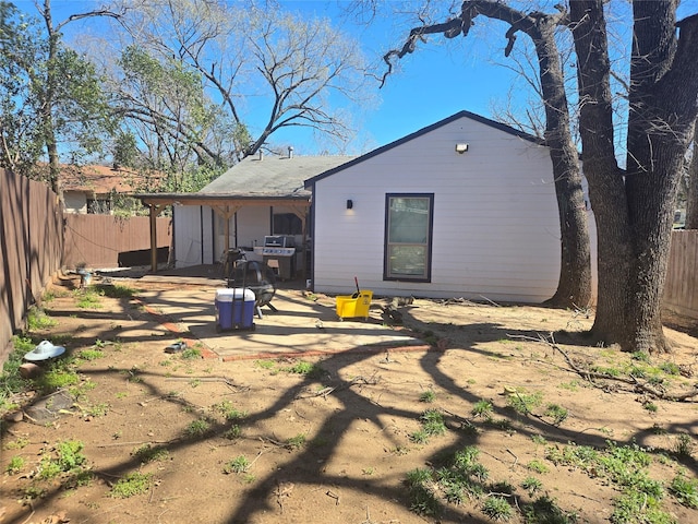 rear view of property with a fenced backyard and a patio