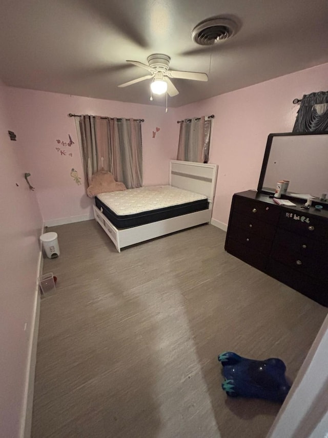 bedroom featuring wood finished floors, ceiling fan, baseboards, and visible vents