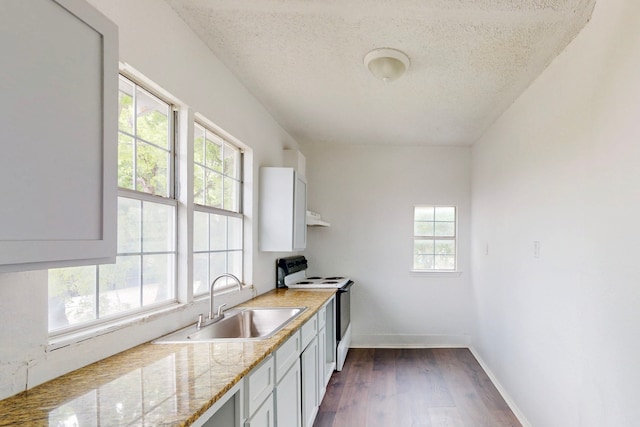 2311 Market Ave, Fort Worth, TX 76164 - kitchen featuring white electric range, a textured ceiling, dark wood-style flooring, a sink, and baseboards