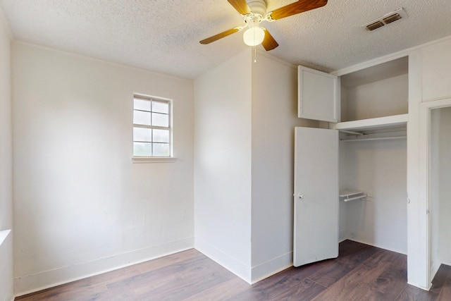 2311 Market Ave, Fort Worth, TX 76164 - unfurnished bedroom with dark wood-style flooring, visible vents, a closet, and a textured ceiling