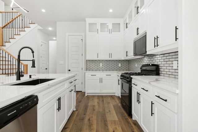 2239 Scotland Dr, Dallas, TX 75216 - kitchen featuring a sink, black gas stove, dark wood finished floors, stainless steel dishwasher, and decorative backsplash