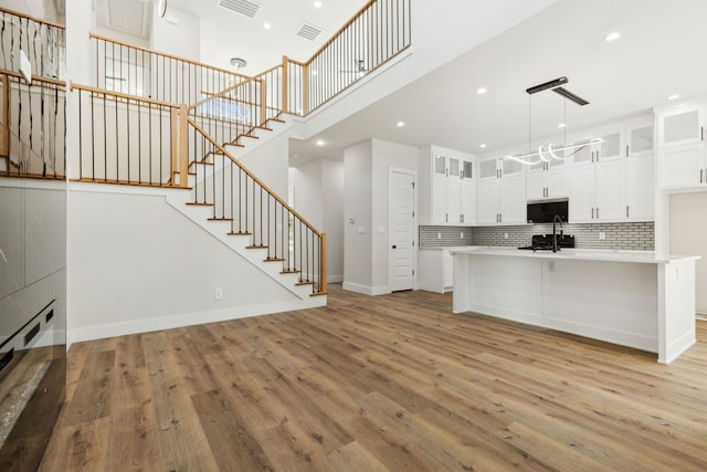 2239 Scotland Dr, Dallas, TX 75216 - kitchen featuring light wood finished floors, visible vents, light countertops, and backsplash
