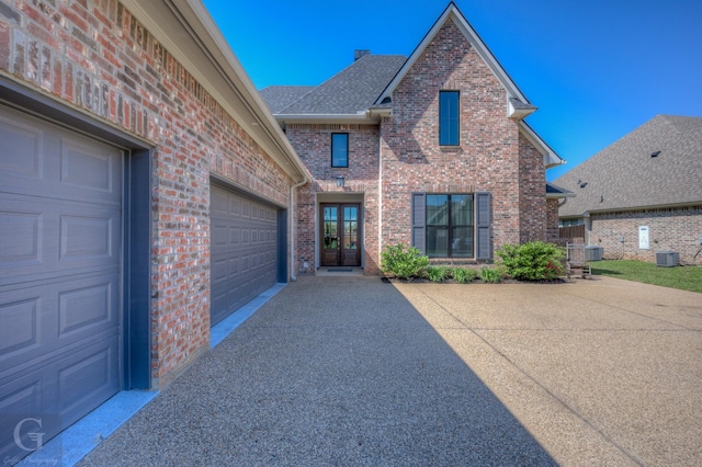 262 Poydras Ave, Bossier City, LA 71111 - traditional home with cooling unit, brick siding, french doors, driveway, and roof with shingles