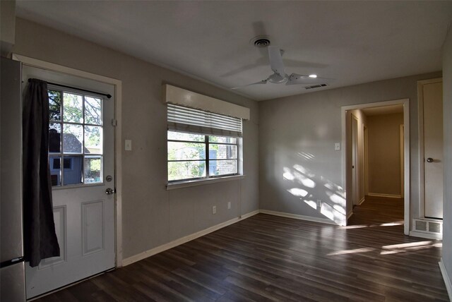 interior space featuring dark wood-type flooring, visible vents, baseboards, and a ceiling fan