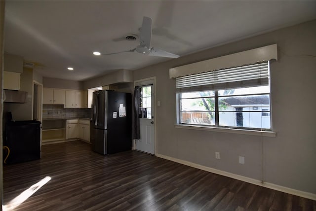 kitchen featuring tasteful backsplash, baseboards, freestanding refrigerator, a ceiling fan, and dark wood-type flooring