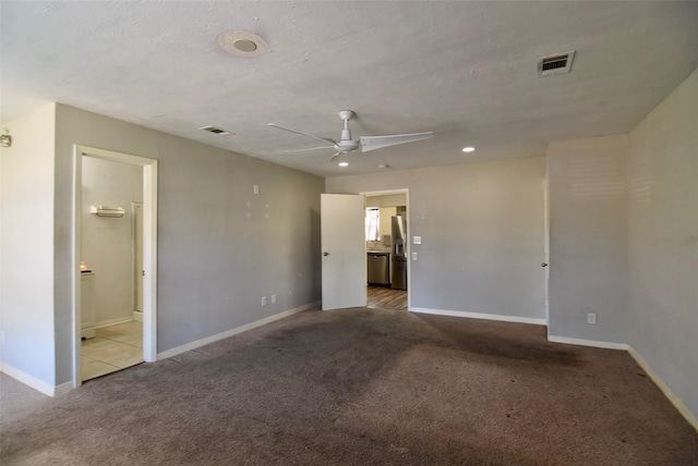 empty room with light colored carpet, baseboards, a ceiling fan, and visible vents