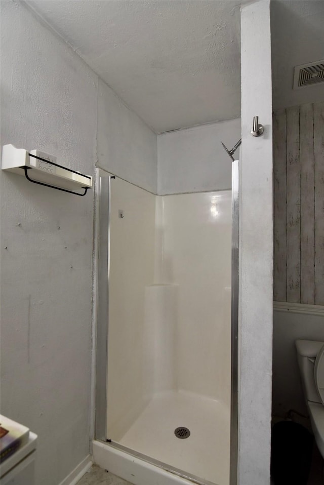 bathroom featuring visible vents, toilet, and a stall shower