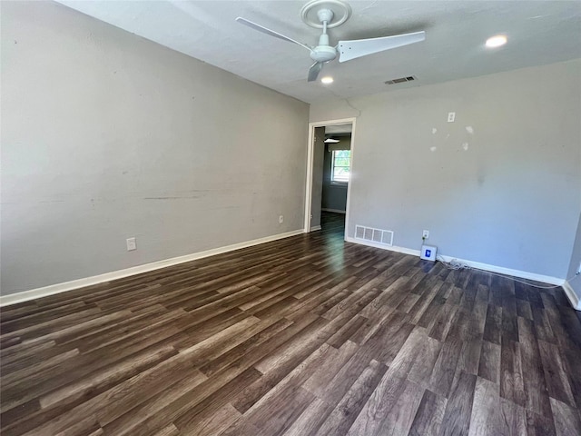 spare room with ceiling fan, baseboards, dark wood finished floors, and visible vents
