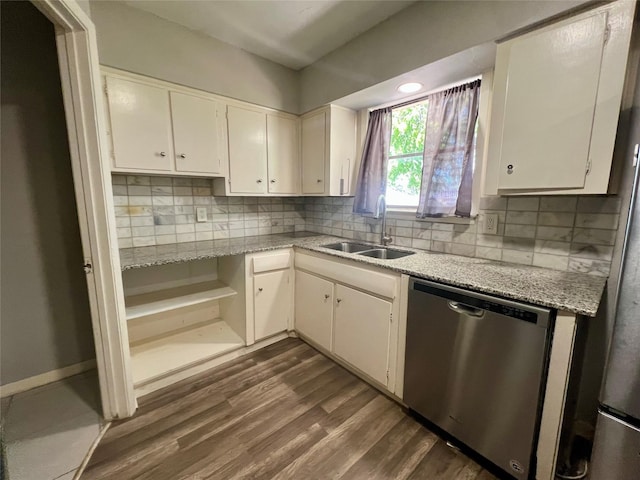 kitchen with backsplash, white cabinets, dark wood finished floors, stainless steel dishwasher, and a sink