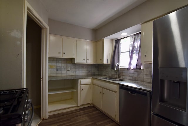 kitchen featuring tasteful backsplash, dark wood-style flooring, white cabinets, appliances with stainless steel finishes, and a sink