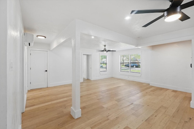 unfurnished living room with light wood-type flooring, ceiling fan, a wall mounted AC, baseboards, and recessed lighting