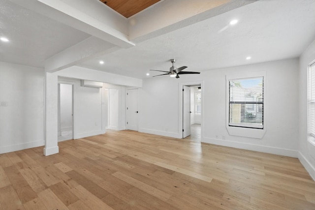 unfurnished living room with recessed lighting, light wood finished floors, baseboards, a wall unit AC, and a ceiling fan
