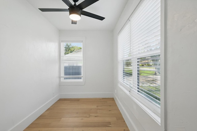 spare room featuring light wood-type flooring, baseboards, and ceiling fan