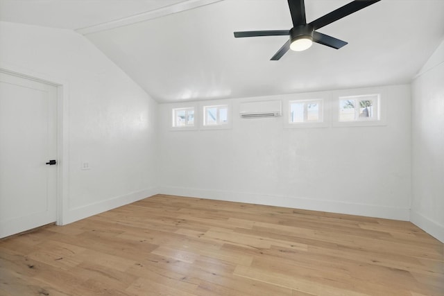 basement with a wall mounted AC, light wood-style floors, healthy amount of natural light, and baseboards