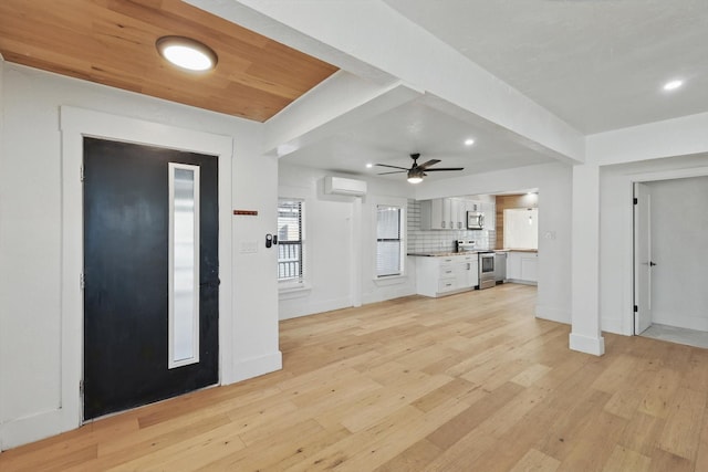 foyer entrance featuring light wood finished floors, a ceiling fan, an AC wall unit, recessed lighting, and baseboards