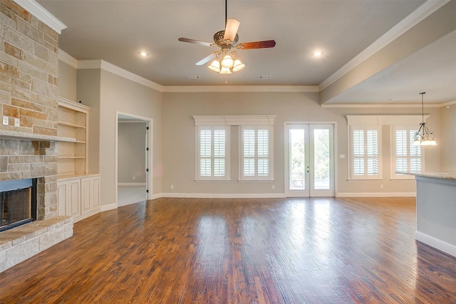unfurnished living room with a stone fireplace, a ceiling fan, ornamental molding, and wood finished floors