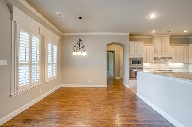 kitchen featuring tasteful backsplash, visible vents, arched walkways, under cabinet range hood, and stainless steel appliances