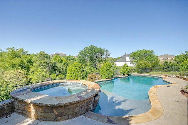 view of pool with a fenced backyard and a pool with connected hot tub