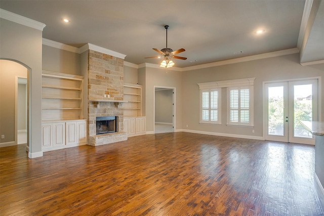 unfurnished living room featuring baseboards, a ceiling fan, wood finished floors, and a fireplace