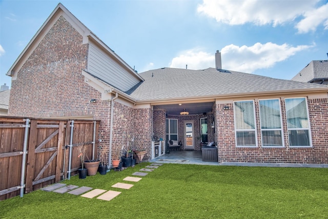 1765 Bramshaw Trl, Farmers Branch, TX 75234 - rear view of house with a gate, fence, a patio area, a lawn, and brick siding